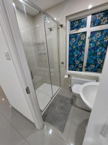 a bathroom with a shower and a toilet and a window at Cosy London Family apartment for 4 persons near Westfield Shepherd's Bush in London