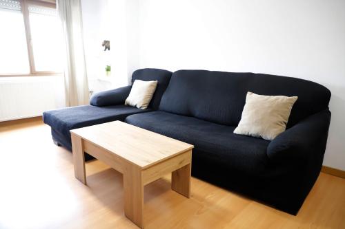 Sofá azul en la sala de estar con mesa de centro en ACOGEDOR Y LUMiNOSO, en Oviedo