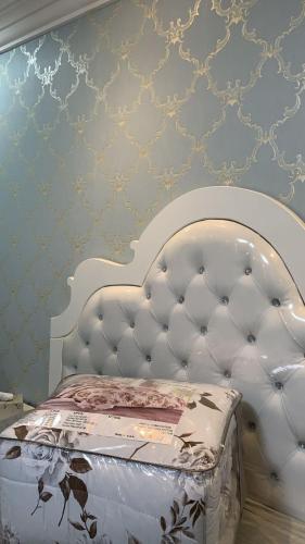 uma cama com uma cabeceira branca num quarto em شقة تنويه ليست للايجار em Al Khobar