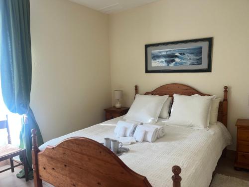 une chambre avec un lit avec des draps blancs et des oreillers dans l'établissement charmante maison de campagne, à Jonzac