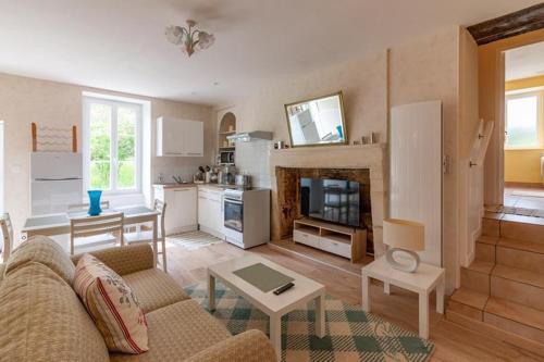 un salon avec un canapé et une cuisine dans l'établissement charmante maison de campagne, à Jonzac