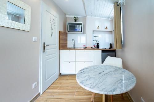 - une petite cuisine avec une petite table et un comptoir dans l'établissement Studio romantique jacuzzi ou spa balneo privatif et jardin Au temps des cerises La Ciotat, à La Ciotat