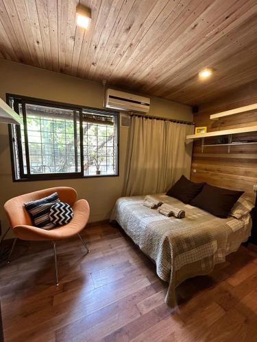 1 dormitorio con 1 cama y 1 silla en DEPARTAMENTO MODERNO ENTERO / EQUIPADO - EXCELENTE UBICACION en Mendoza