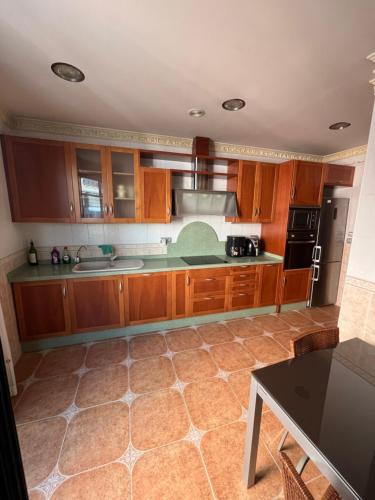 cocina con armarios de madera y encimera en Suite en el centro de Elche, en Elche