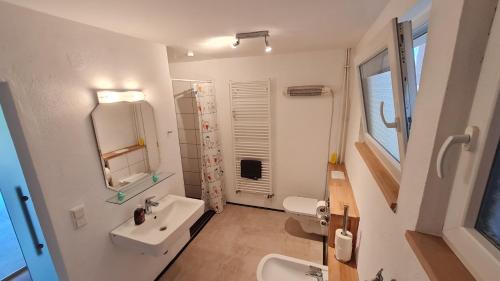 a white bathroom with a sink and a mirror at Haus an der Weser in Oedelsheim