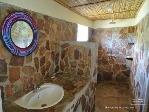 a bathroom with a sink and a stone wall at Oseki Maasai Mara Camp in Narok