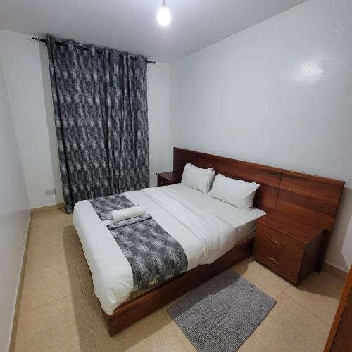 um quarto com uma cama grande e uma cabeceira em madeira em Unity Homes G em Eldoret