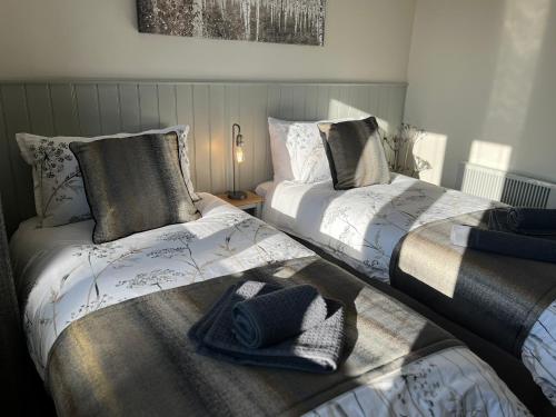 two beds sitting next to each other in a bedroom at Woodside-Filey in Filey