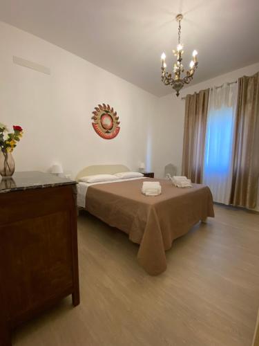 1 dormitorio con cama y lámpara de araña en La tenuta di Eva en Pisa