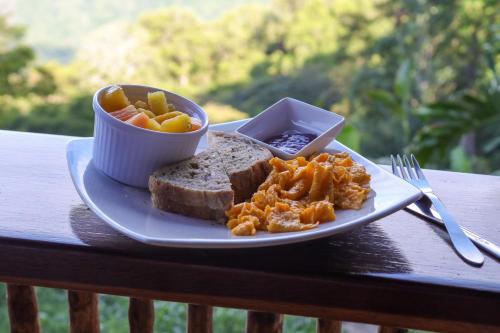 a plate of food with bread and a bowl of fruit at Mano Verde Minca in Minca