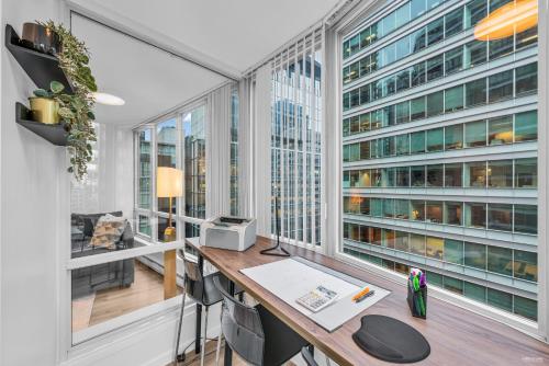 an office with a desk and large windows at 1-BR Condo in Downtown Coal Harbour with Parking and City Views in Vancouver