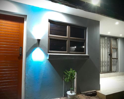 a house with a blue light under a window at White City Gardens, Empangeni, Ngwelezana in Empangeni