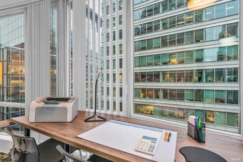 an office with a desk with a printer and windows at Chic 1BR Condo in Coal Harbour in Vancouver