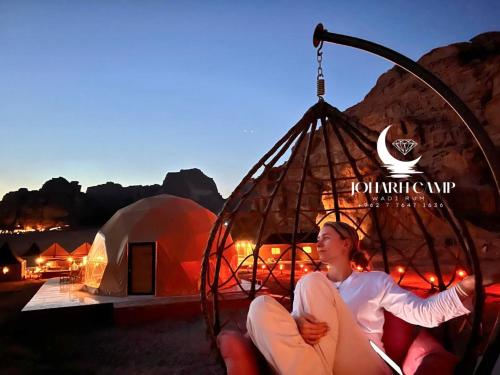 a woman sitting in a swing in front of a tent at RUM JOHARH lUXURY CAMP in Wadi Rum