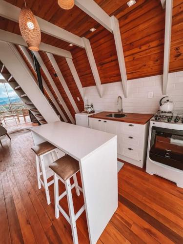 a kitchen with a counter and a stove top oven at Casa Di Legno Cabana com Spa, Ofurô e Vista para as Montanhas in Urubici