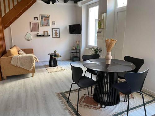 un salon avec une table et des chaises dans l'établissement Maison proche centre ville, à Châteauroux