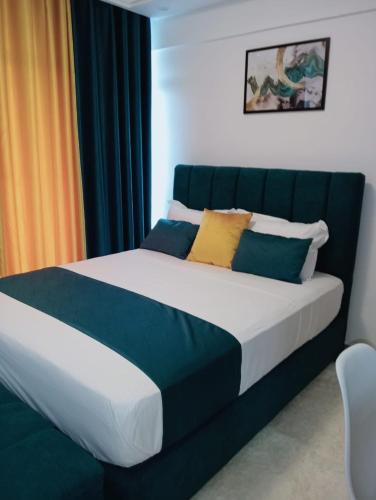 a bedroom with a bed with blue and yellow pillows at Wanderstay kenya in Nairobi