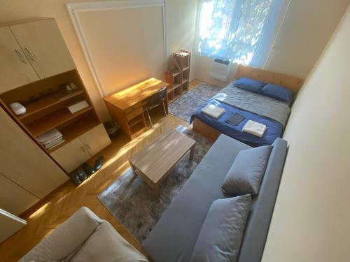 Cette petite chambre comprend un lit et un canapé. dans l'établissement Ögünc’s Apartment, à Szeged