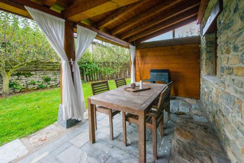 a wooden table and chairs on a patio at Egur Etxe I Caserío Vasco I Jardín I Porche I BBQ I Chimenea in Zárate