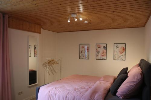 a bedroom with a bed and a wooden ceiling at Ferienhäuschen Brohlbachtal in Gamlen