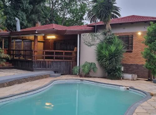 a swimming pool in front of a house at Marandela Guesthouse in Louis Trichardt