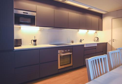 a kitchen with dark purple cabinets and white counters at SBC Guest House in Pajala