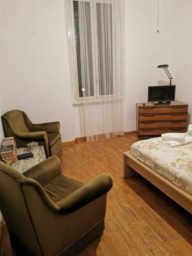 una camera da letto con due sedie e un letto e un comò di La Casetta a Roma