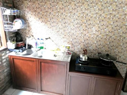 a small kitchen with a stove and a sink at Semar88 Guest House in Balong