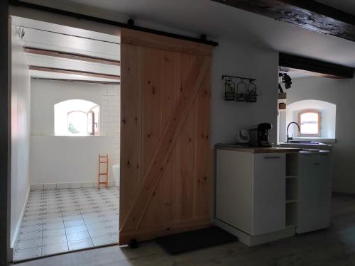 Una puerta de madera en una cocina con encimera en Wieża Gniezno Apartament KRÓL, en Gniezno