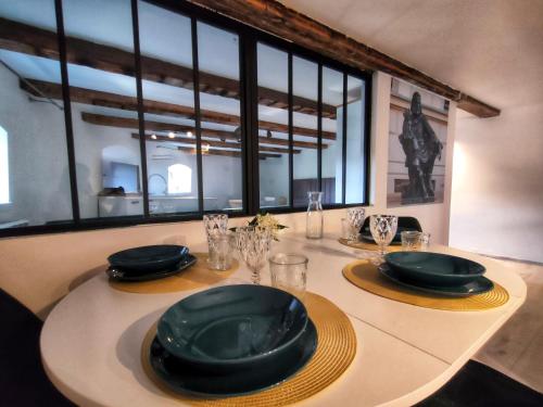 una mesa con platos negros y servilletas. en Wieża Gniezno Apartament KRÓL en Gniezno