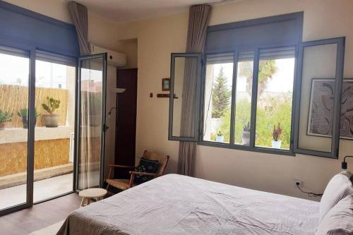 a bedroom with a bed and a large window at The cactus house in Casablanca