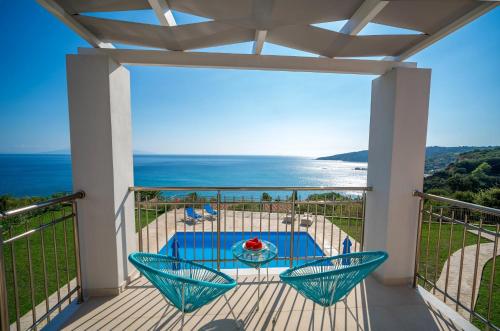 a balcony with a table and chairs and the ocean at Kefalonian Gems in Pesádha