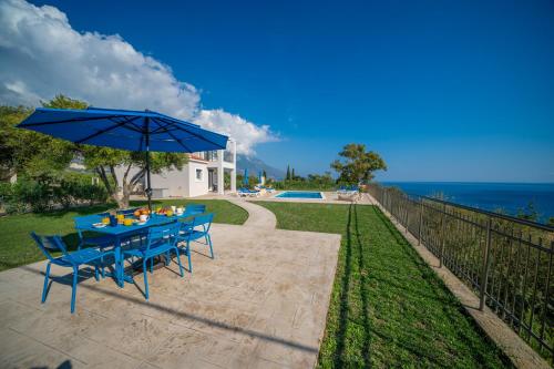 a blue table with chairs and an umbrella at Kefalonian Gems in Pesádha