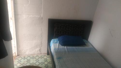 a small bed in a corner of a room at Casa San Alonso in Bucaramanga