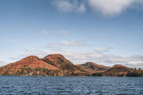 a large body of water with mountains in the background at Lake Resort Suite: Views & Amenities in Lac-Superieur