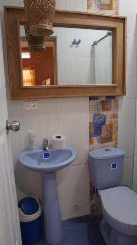 uma casa de banho com um WC, um lavatório e um espelho. em Los Cayos Cabañas em Coveñas