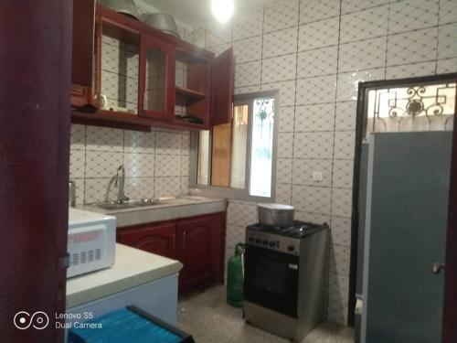 una cucina con fornelli e frigorifero di Ramakyri room a Douala
