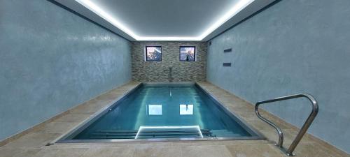 a swimming pool in a room with two windows at CHATEAU DE MAILLAT in Maillat