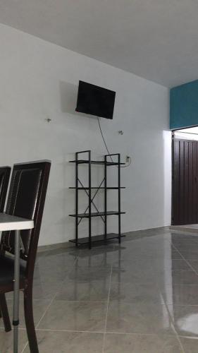 einen TV an der Wand in einem Zimmer mit Stühlen in der Unterkunft Cuarto 2 in Oxkutzcab