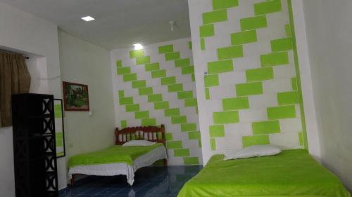 ein Schlafzimmer mit grünen und weißen Quadraten an der Wand in der Unterkunft Cuarto 2 in Oxkutzcab
