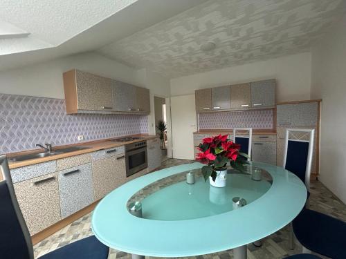 a kitchen with a table with a vase of flowers on it at GardenApartment in Frankfurt