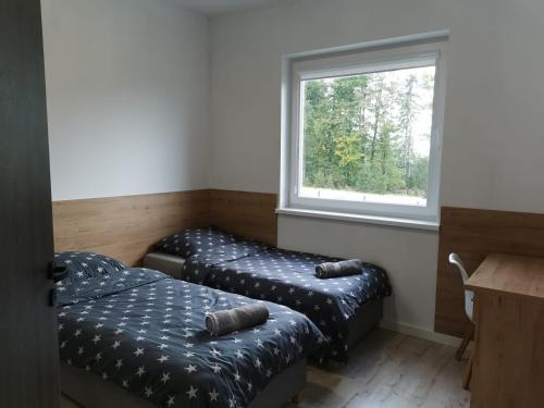 a room with two ottomans and a window at Apartamenty pod Jagodną in Spalona