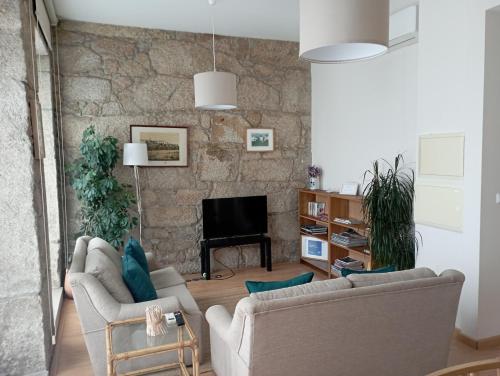 a living room with two couches and a television at Casas Marias de Portugal - Cerveira in Vila Nova de Cerveira