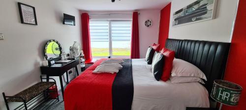 a bedroom with a bed and a desk and a window at Cadillac Kustomz Hotel in Rothesay