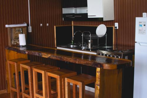 a kitchen with a counter and some wooden stools at Sector 3 de Camping Angostura in Las Cabras