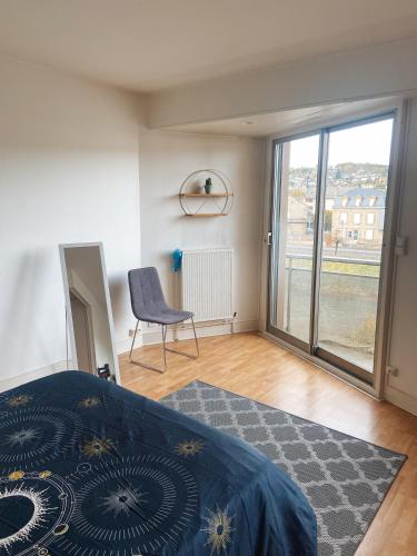 une chambre avec un lit, une chaise et une fenêtre dans l'établissement Le Bouton d or, Studio Lumineux avec vue et parking privé, à Brive-la-Gaillarde