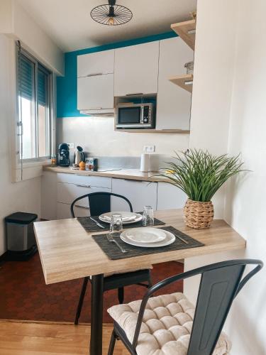 une petite cuisine avec une table et des chaises en bois dans l'établissement Le Bouton d or, Studio Lumineux avec vue et parking privé, à Brive-la-Gaillarde