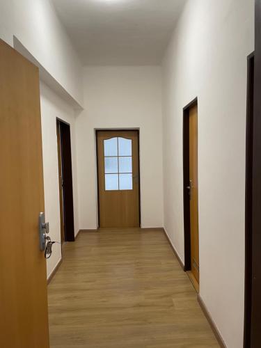 an empty hallway with two doors and a wooden floor at Apartman T&T in Cheb