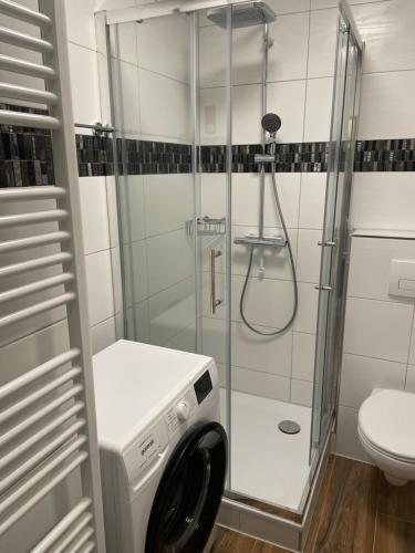 a bathroom with a shower and a washing machine at Paris3 in Oberhausen