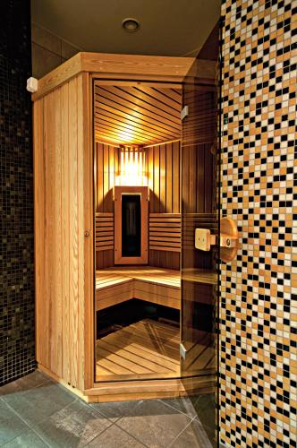 a wooden sauna with a glass door in a room at Łeba Hotel & Spa in Łeba